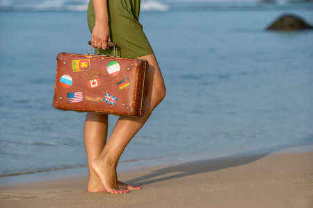 Beautiful girl with a old vintage suitcase in a beachの写真素材