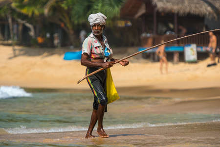 WELIGAMA, SRI LANKA -  JANUARY 18, 2017:  Portrait of local fisherman sitting on boat. Tourism and fishing are two main business in this town.のeditorial素材