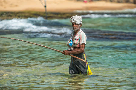 WELIGAMA, SRI LANKA -  JANUARY 18, 2017:  Portrait of local fisherman sitting on boat. Tourism and fishing are two main business in this town.のeditorial素材