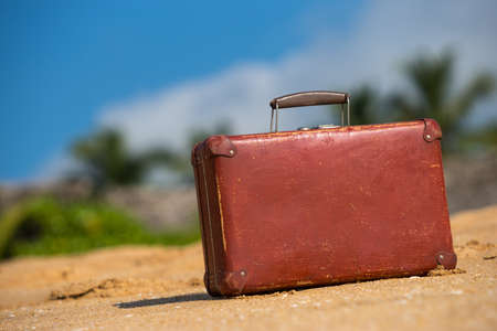 Travel  vintage suitcase is alone on a beachの写真素材