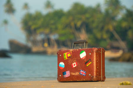 Travel  vintage suitcase is alone on a beachの写真素材