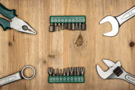 Top view of different type of constructive tools with copy space on wooden background. Construction...