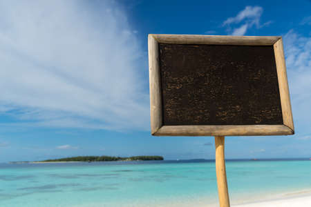 blank black board on tropical beach background.の写真素材