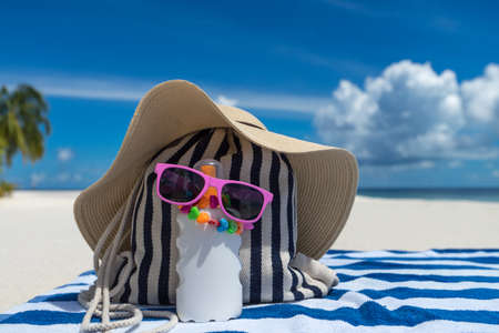 Sunscreen, hat and sunglasses on tropical beachの写真素材