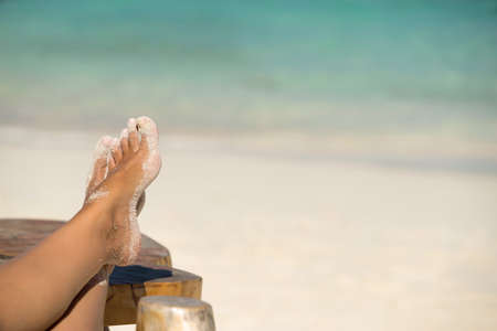 Close-up of female foot in the blue water on the tropical beach. Vacation holidays.の写真素材