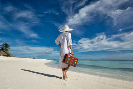 Beautiful girl with a old vintage suitcase in a beachの写真素材