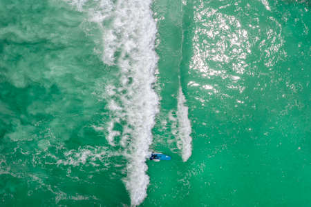 Surfers in tropical ocean waiting wave. Aerial view made with droneの写真素材