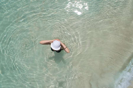 Aerial drone aerial view of Beautiful girl having fun on the sunny tropical beach. Seychelles