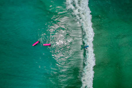 Surfers in tropical ocean waiting wave. Aerial view made with droneの写真素材
