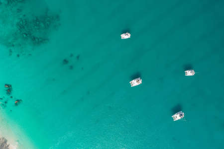 Spectacular aerial view of some yachts and small boats floating on a clear and turquoise sea, Seychelles in the Indian Ocean.Top view from droneの写真素材
