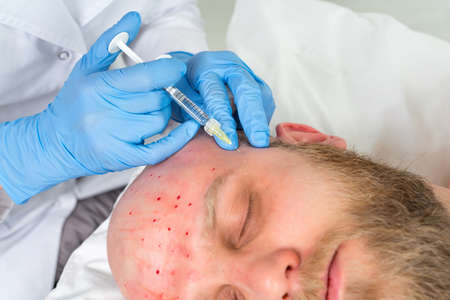 Handsome man is getting injection. Concept of aesthetic beauty.
