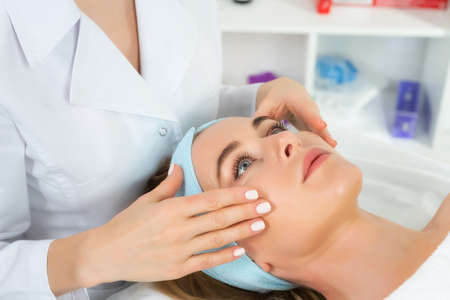 Female beautician doctor with patient in wellness center. Professional cosmetologist make procedure...