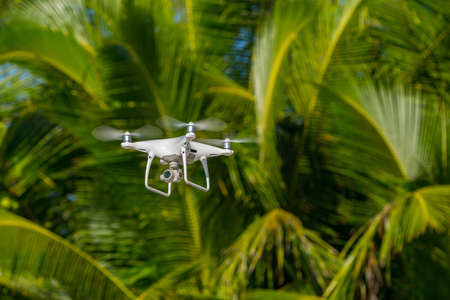 MOSCOW, RUSSIA - 2 October, 2017: a Phantom 4 Pro drone in flight, green trees in the background, selective focus on the drone. Phantom 4 Pro is a drone manufactured by the DJI company.のeditorial素材
