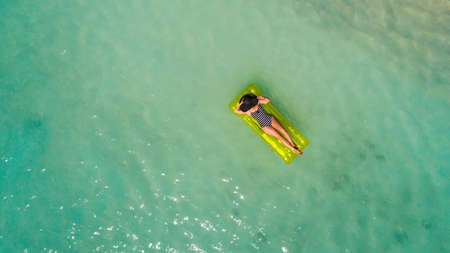 Aerial drone aerial view of Beautiful girl having fun on the sunny tropical beach. Seychellesの写真素材