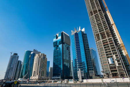 DOHA, QATAR - NOVEMBER 23, 2019: The West Bay City skyline in a beautiful blue sky day - in Doha,...