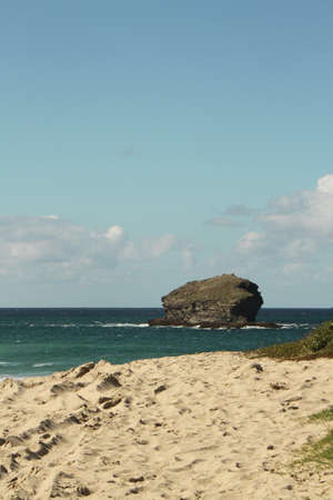 Sea view from sandy beach to large rockの写真素材