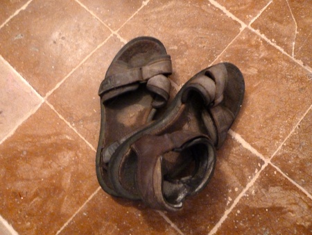 old tatty sandals on a terracotta floorの写真素材