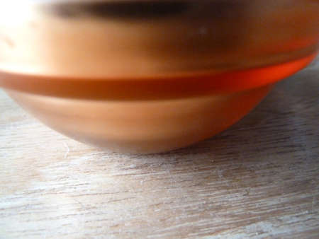 Bright orange and gold object on a wooden surfaceの写真素材