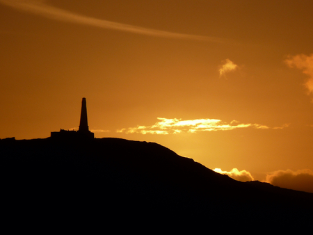 Old decaying hilltop monument in bright sunsetの写真素材