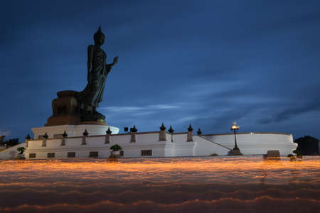 Buddhist walk with lighted candles in hand around a statue of Buddha の写真素材