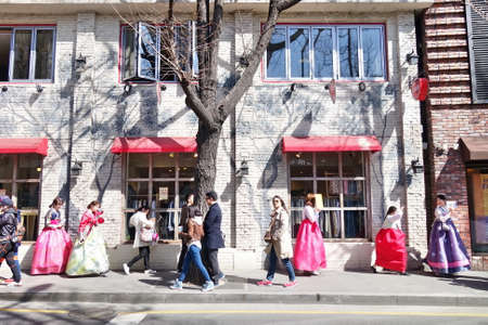 A group of young girls in Korean traditional dress 'Hanbok' are walking along the street of Seoulのeditorial素材