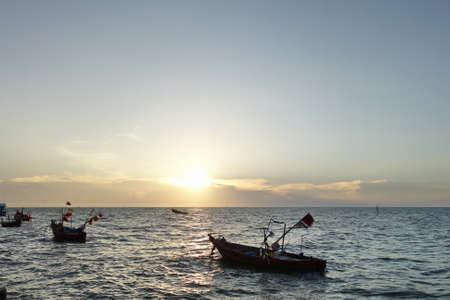 Fishing boats in the sea at sunset.の写真素材
