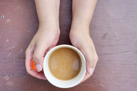 Hand holding coffee cup , top view.の写真素材