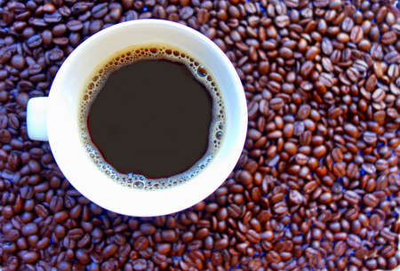 Coffee cup on coffee beans background.