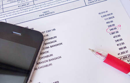 payment bill with red pen and phone.の写真素材