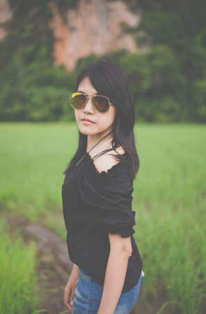 Portrait a beautiful asian woman wearing glasses at cornfield in the morningの写真素材