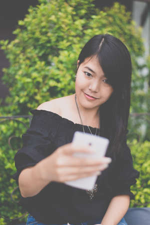 Portrait a beautiful asian smiling selfie in gardenの写真素材