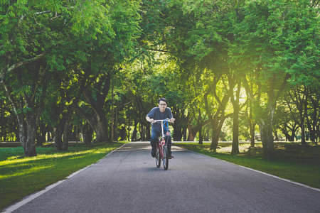 Asian man riding bicycles in the park at morningの写真素材
