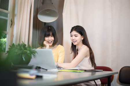 Young asian couple students using labtop in college libraryの写真素材