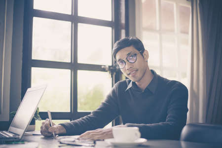 Businessman making notes while working at officeの写真素材