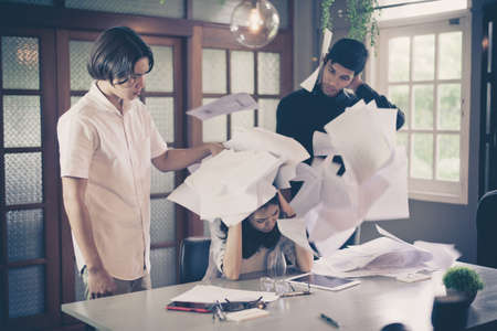 Group of young freelancer people throwing documents and celebrating success