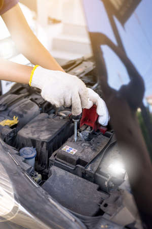 Closeup of hand mechanic engineer fixing car battery at garage, concept car maintenanceの写真素材