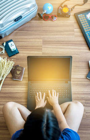 Travel and vacation concept,using laptop with items on wooden floor,Top view with copy spaceの写真素材