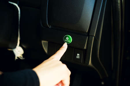 Finger pressing button econ mode switch in carの写真素材