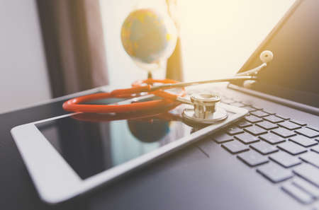 Stethoscope on tablet and laptop,Healthcare and medical concept,Selective focus