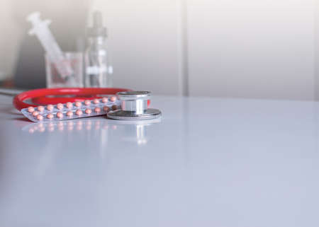 Stethoscope red color with birth control pill on table,Healthcare and medical conceptの写真素材
