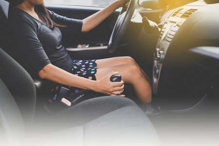 Hands of female driver on steering wheel and automatic gear,Woman driving a carの写真素材