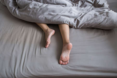 Close up of  barefoot,Feet and stretch lazily on the bed after waking upの写真素材