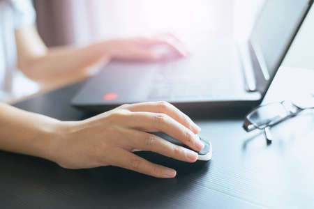 Close up of hand woman holding credit card and using laptop for online shopping concept