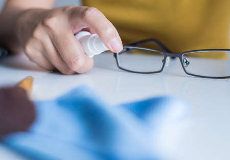 Hand woman cleaning her glasses,Clean lenses of eyeglasses,Selective focus handの写真素材