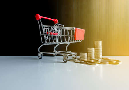 Mini shopping cart with step of coins stacks,Finance and money shopping conceptの写真素材
