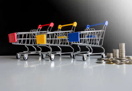 Mini 3 shopping cart with step of coins stacks,Finance and money shopping conceptの写真素材