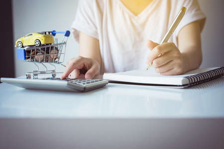 Saving money for cars with coins on mini shopping trolley cart,Car finance and loan concept,Selective focusの写真素材