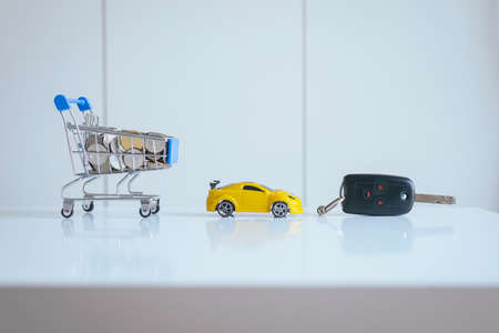 Saving money for cars with coins on mini shopping trolley cart,Car finance and loan conceptの写真素材