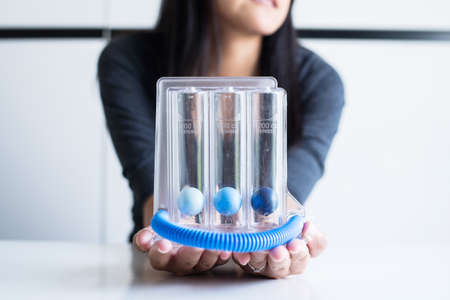Woman hand holding  incentivespirometer or three balls for stimulate lung