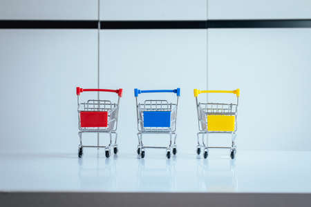 Mini three shopping cart or supermarket trolley on table,Finance and money shopping conceptの写真素材